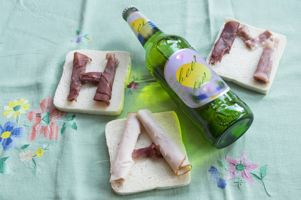 γρήγορο φαγητό με σάντουιτς, γεμάτη με ζαμπόν και μπύρα ως ποτό - Φωτογραφία, εικόνα