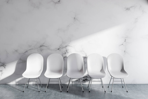 Row of white chairs standing along the white wall in a gray floor empty room. Waiting room design of a clinic office company. 3d rendering mock up wall - Φωτογραφία, εικόνα