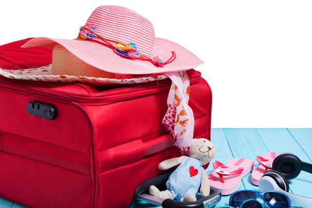 Concepto de viaje con gran bolsa de viaje roja y accesorio para el viaje sobre fondo blanco
 - Foto, Imagen