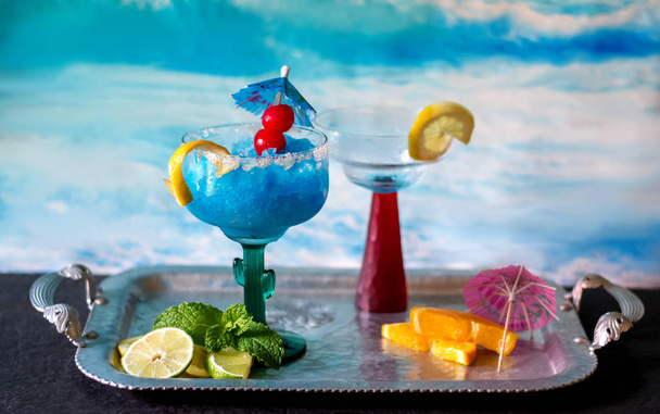 ein bunter blauer gefrorener Cocktail mit Kirsch- und Zitronengarnitur. Ein Drink ist nie genug - Foto, Bild