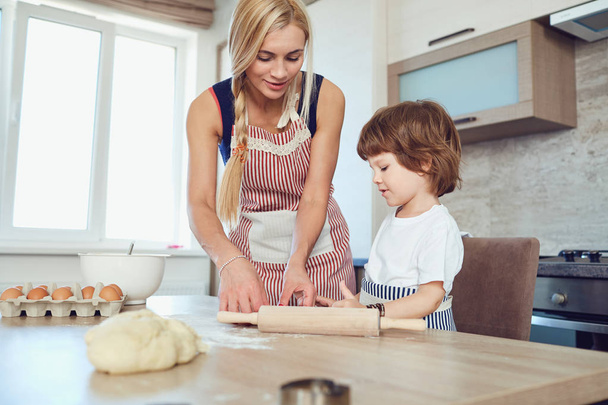 Mother and son bake cakes in the kitchen. - Fotoğraf, Görsel