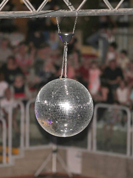 Big disco ball at the concert that reflects light directed at it in many directions - Photo, Image