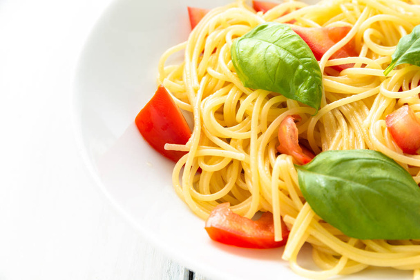 Dish of spaghetti with fresh tomatoes and basil leaves, Mediterranean food  - Photo, Image
