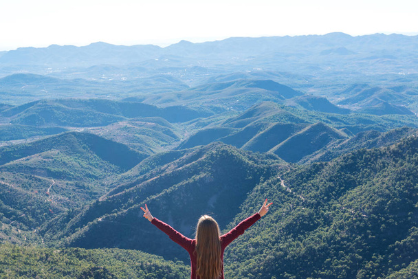 Beautiful women showing peace sign while enjoying mountains landscape - Foto, Bild