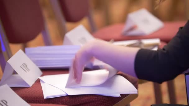 Γυναικεία χέρια προετοιμάζοντας έγγραφα για τους συμμετέχοντες στο Συνέδριο - Πλάνα, βίντεο