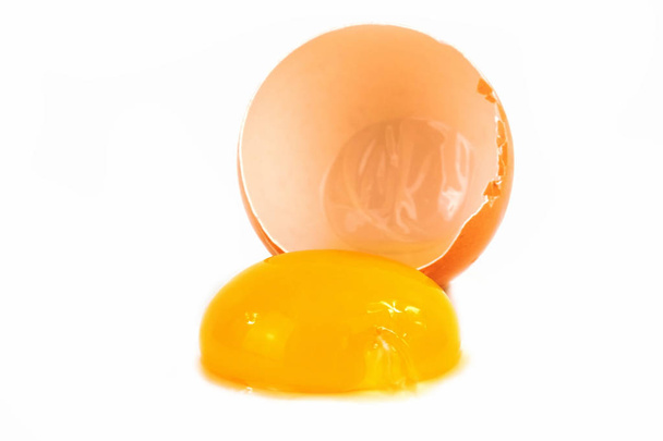 Ei gebrochen, Nahaufnahme von Eierschale mit Eigelb auf weißem Hintergrund - Foto, Bild