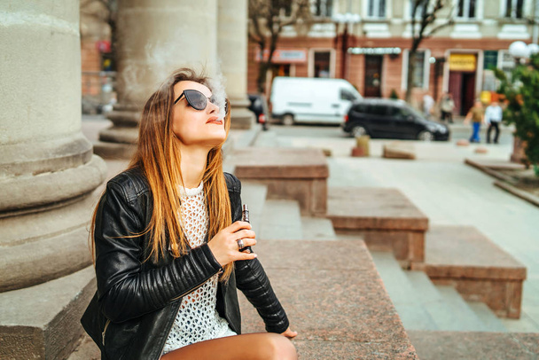 Pretty woman smoke electronic cigarette outdoor - Zdjęcie, obraz