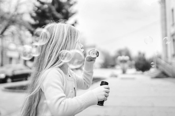 Little pretty baby girl blowing bubbles outdoor - 写真・画像