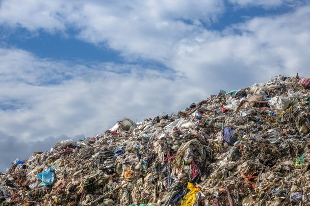Свалка мусора, пейзаж с травой и голубым небом
 - Фото, изображение