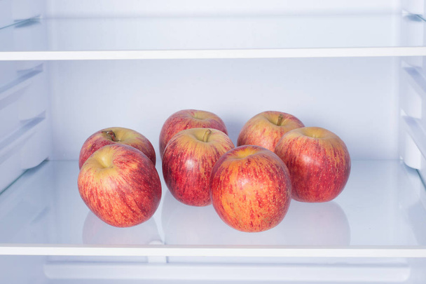 Open fridge, apples on the shelf of refrigerator, healthy nutrition concept - Foto, immagini