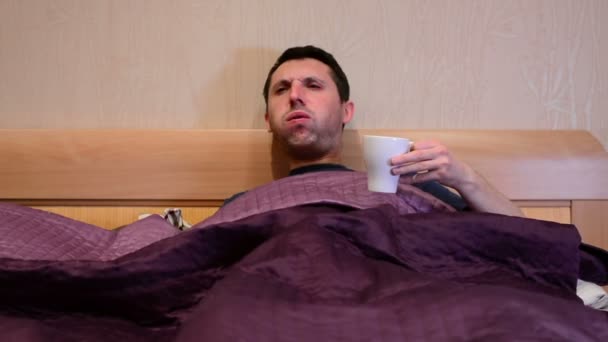 Chory chory człowiek kaukaski kaszel w łóżku. - Materiał filmowy, wideo