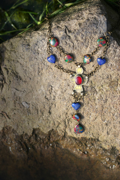 Necklace on the stone on sunny day - Photo, Image