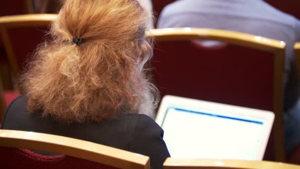 Achterzijde weergave vrouw die werkt met de laptop op een conferentie - Video