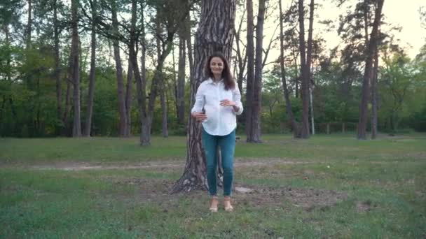 έγκυος γυναίκα που κρατώντας την κοιλιά, τα πόδια κάτω από το καλοκαίρι προσπαθεί - Πλάνα, βίντεο