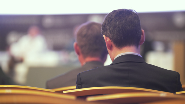 Vista trasera del joven sentado en la conferencia de negocios
 - Metraje, vídeo