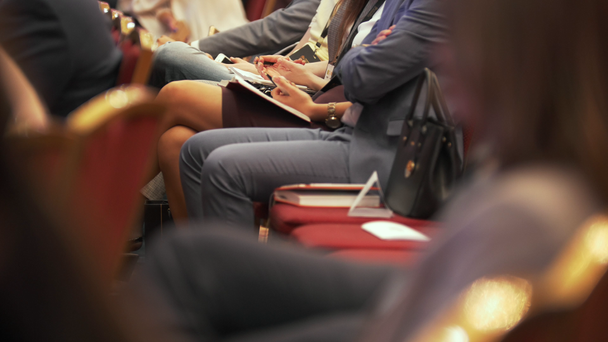 Personas en sus asientos escuchando y escribiendo en la conferencia de negocios
 - Metraje, vídeo