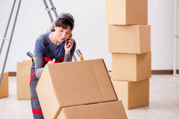 Woman contractor moving boxes in relocation concept - Foto, Imagen