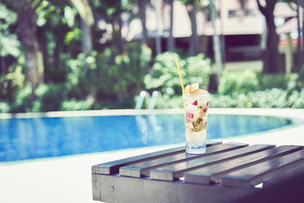 Egy pohár víz gyümölcslé a medence, a pihenés és a nyári idő. - Fotó, kép