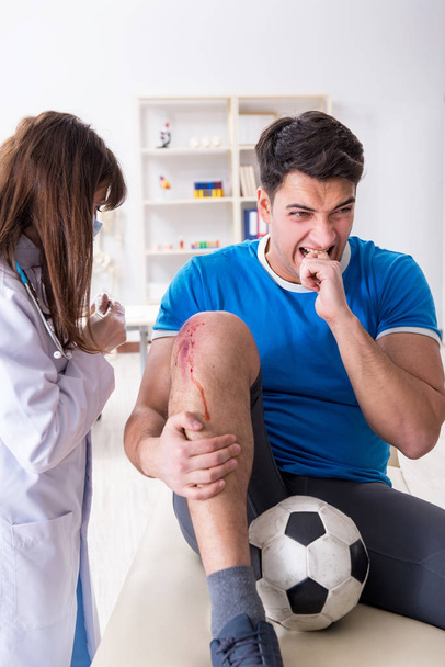 Футболіст відвідує лікаря після травми
 - Фото, зображення