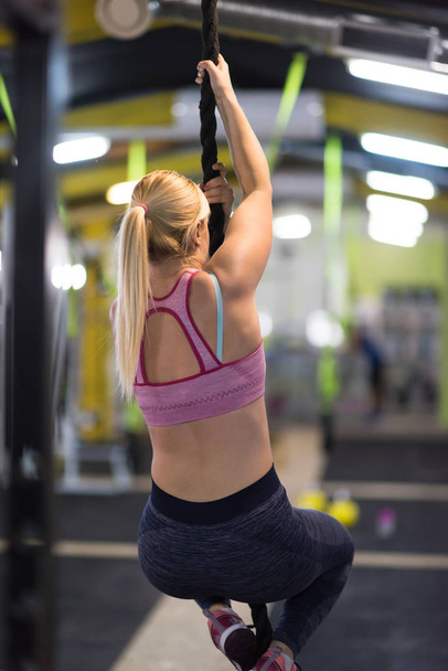 young muscular woman doing rope climbing in cross fitness gym - Φωτογραφία, εικόνα