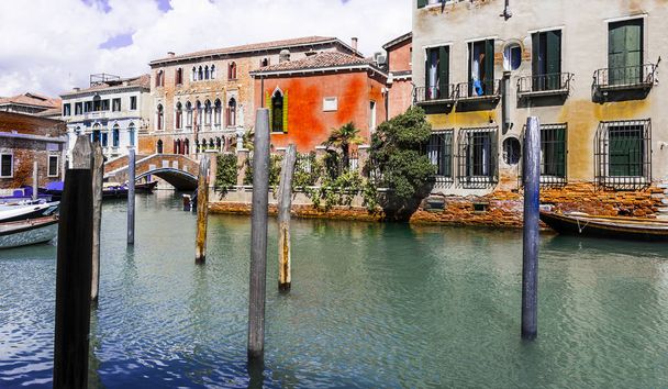 Casas que se desprenden de la humedad. Venecia está situada a través de un grupo de islas que están separadas por canales y unidas por puentes. La góndola es un bote de remos veneciano tradicional de fondo plano
 - Foto, Imagen