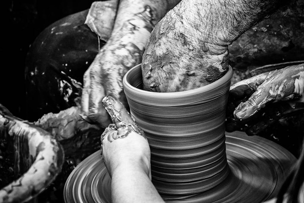 Handen van de mens werken en vormgeven klei, pottenbakker in aardewerk, ambachtelijke detail, creatie - Foto, afbeelding