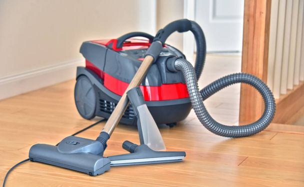 Aspirapolvere contenitore per uso domestico sul pavimento in appartamento. - Foto, immagini