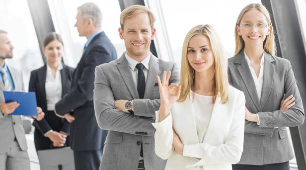 Прекрасная деловая команда с скрещенными руками в офисе, женщина с хорошим знаком
 - Фото, изображение