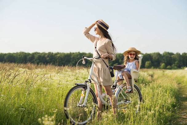 Madre e hija tienen paseo en bicicleta en la naturaleza. Actividad de verano
 - Foto, imagen