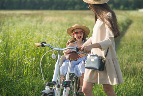 Mother and daughter have bike ride on nature. Summertime activity - Fotografie, Obrázek