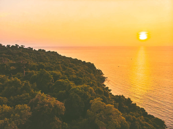 Ilmakuva merelle ja rannalle kookospalmulla saarella auringonlaskun aikaan
 - Valokuva, kuva