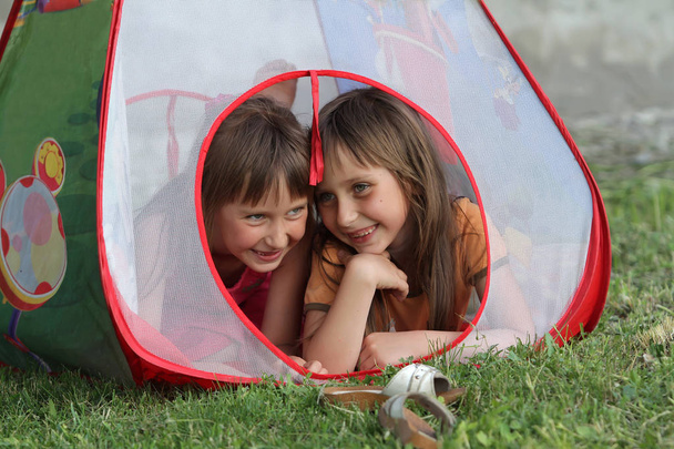Deux sœurs dans une tente de jeux pour enfants parlent. Les filles sont secrètes dans la loge de leurs enfants
. - Photo, image