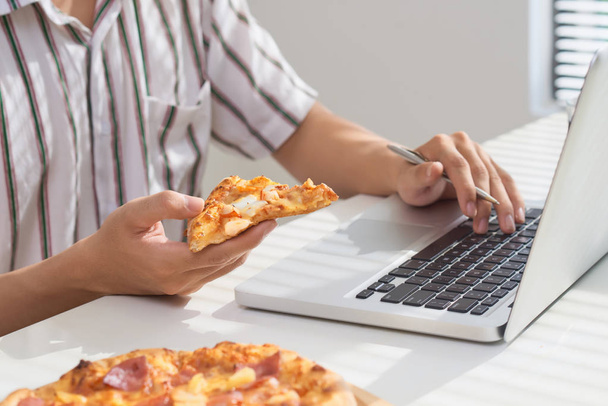 Táplálkozás pizza és társadalmi hálózat-val egy laptop. - Fotó, kép