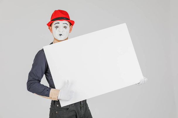happy MIME artist holding a blank white Board, on a white background - Foto, imagen