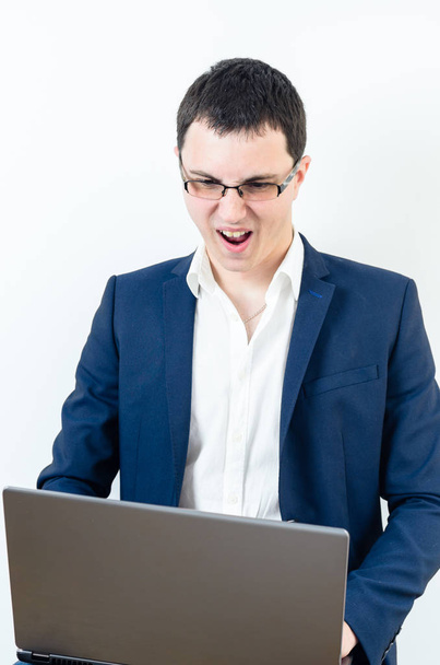 Young businessman wearing glasses and looking on his laptop - Foto, afbeelding