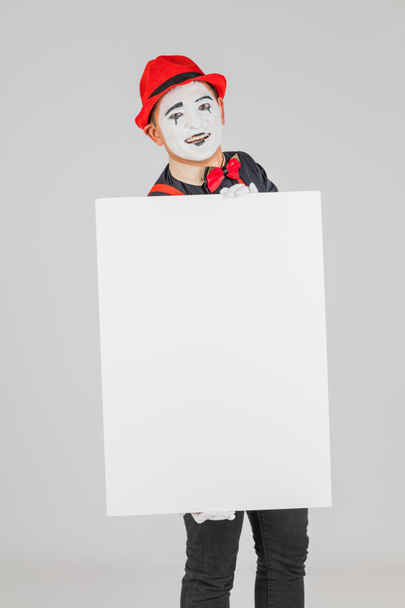 glücklicher MIME-Künstler mit einem leeren weißen Brett auf weißem Hintergrund - Foto, Bild
