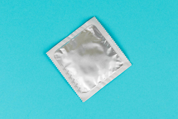 Mavi bir arka plan üzerinde prezervatif. - Fotoğraf, Görsel