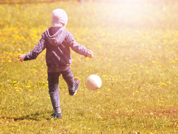 少年は、スポーツの芝生の上のボールをキックします。 - 写真・画像