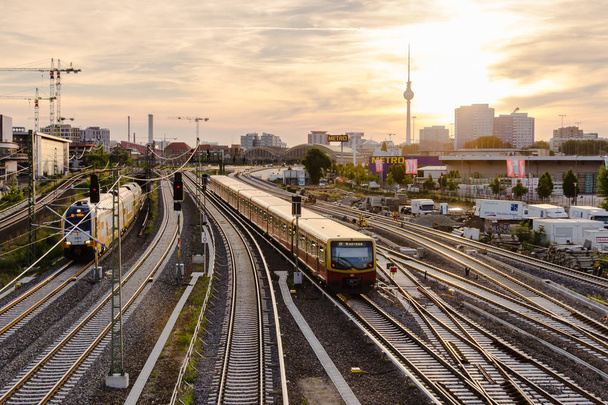 Berlim, Alemanha, 6 de junho de 2018: vista das trilhas ferroviárias e da torre de TV da ponte de Varsóvia (rua Varsóvia) ao pôr do sol
. - Foto, Imagem