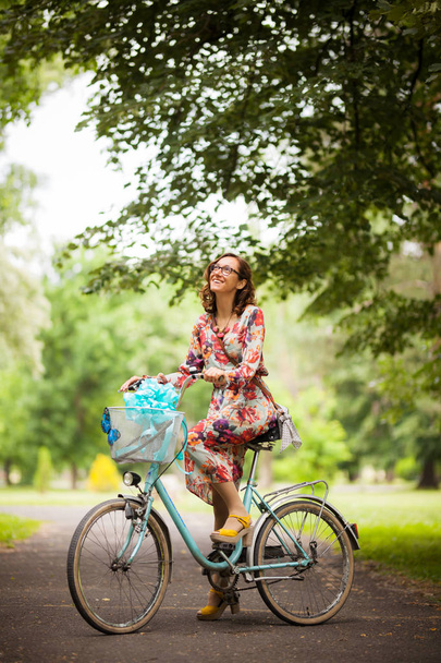 girl with vintage bicycle on a road in the park - Fotoğraf, Görsel