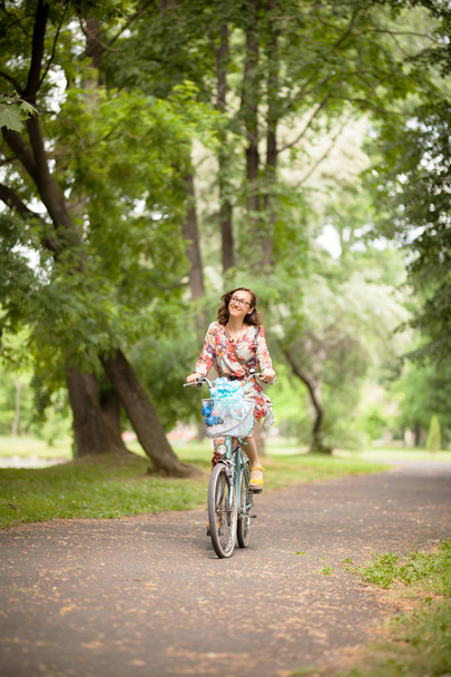 girl with vintage bicycle on a road in the park - Фото, изображение