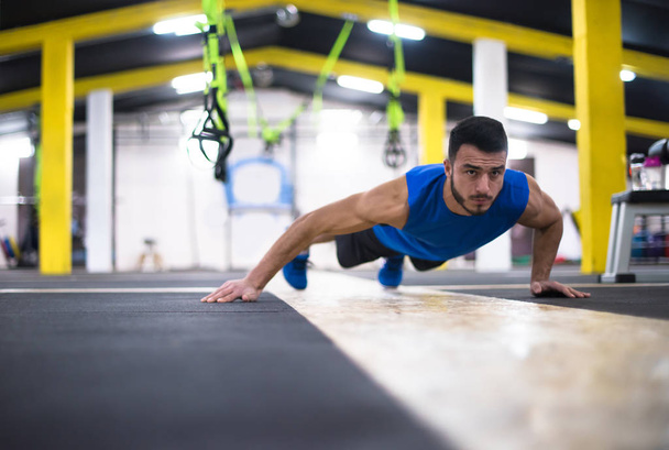 Young strong man doing pushups  at cross fitness gym - Φωτογραφία, εικόνα