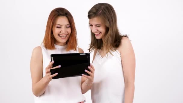 Dos mujeres jóvenes usando una tableta PC y riendo
 - Imágenes, Vídeo