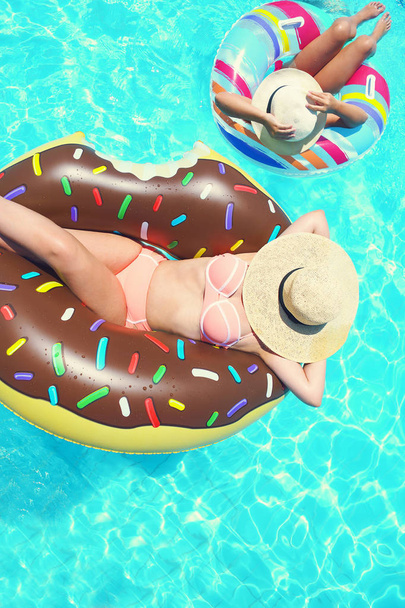 Two people mom and child relaxing on donut in the pool summer holiday - Foto, Imagem