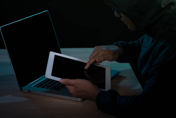 Hacker de crimes cibernéticos com capuz usando hackers de internet tablet digital no ciberespaço
 - Foto, Imagem
