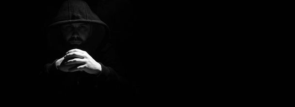 Чоловік в чорному капюшоні і кулаки
 - Фото, зображення