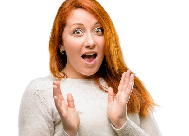 Beautiful young redhead woman happy and surprised cheering expressing wow gesture isolated over white background - Foto, Imagen