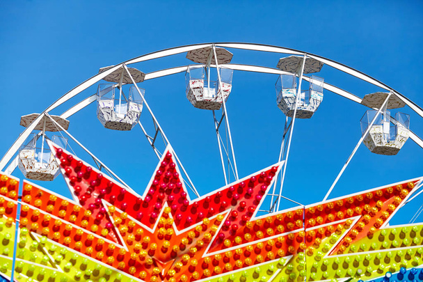 Ferris wheel in an amusement park against the blue sky. - Photo, Image