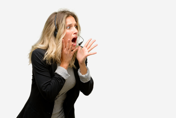 Fiatal nő operátor call center stresszes vezetése kezében fejét, rémült, pánik, kiabálva - Fotó, kép