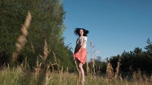 Güzel bir genç kadın neşeyle yürüyüş ve ormanda atlamalı. Ağır çekim - Video, Çekim
